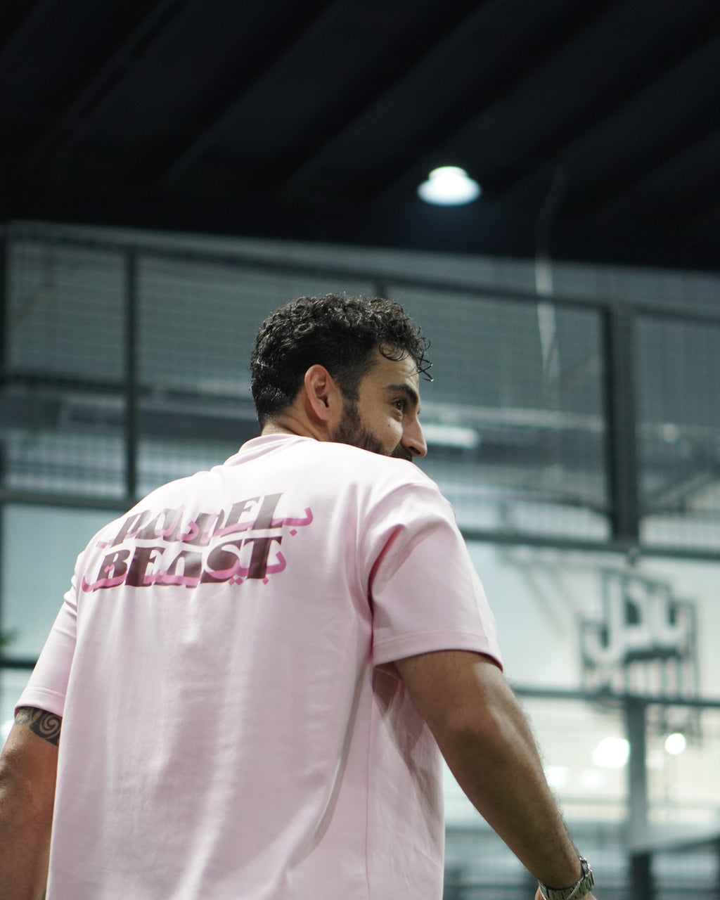 Padel Beast Arabic English pink tee worn on court, back print