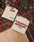 Padel Pretty Girls tee in cream with oxblood print, folded front and back
