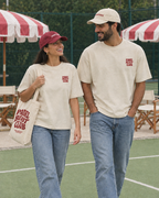 Couple wearing the Padel Beast Club cream tee at the padel club