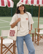 Padel Besties Club cream tee on a woman, front, with tote bag